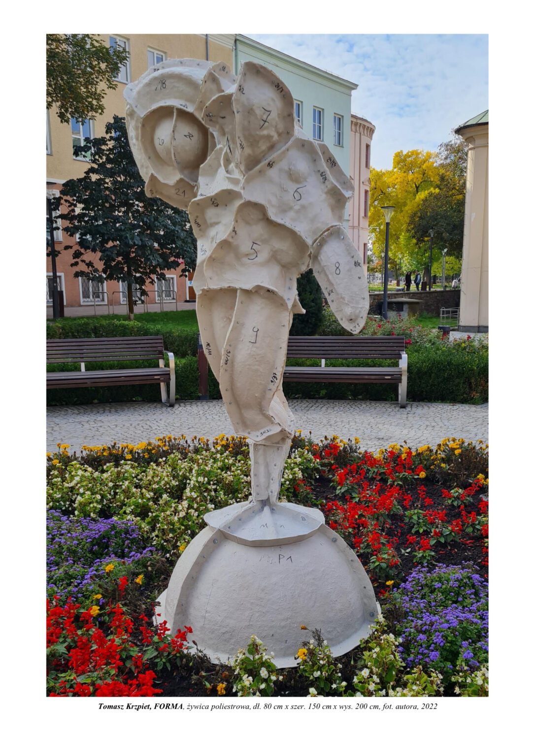 Rzeźba kobiety zamkniętej w skorupie skręcanej na śruby. Stoi na jednej nodze na półkuli. Jej struktura tworzy się i pączkuje przez podział komórkowy. Nie jest to oczywiste, gdyż jest na niej powłoka, skorupa złożona z wielu mniejszych elementów, które dokładnie pasują do siebie i ściśle chronią wnętrze. Kompozycja rzeźbiarska w kolorystyce bieli.