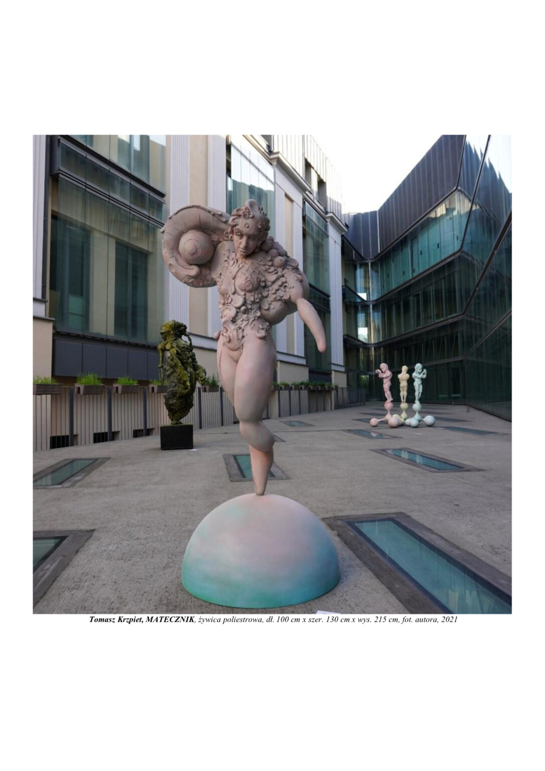 Rzeźba kobiety zbudowanej z atomów. Stoi na jednej nodze na półkuli. Jej ciało i struktura tworzą się, pączkują przez podział komórkowy.